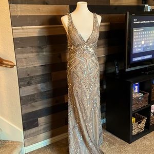 Daring gold and silver gown with plunging neckline and open back.